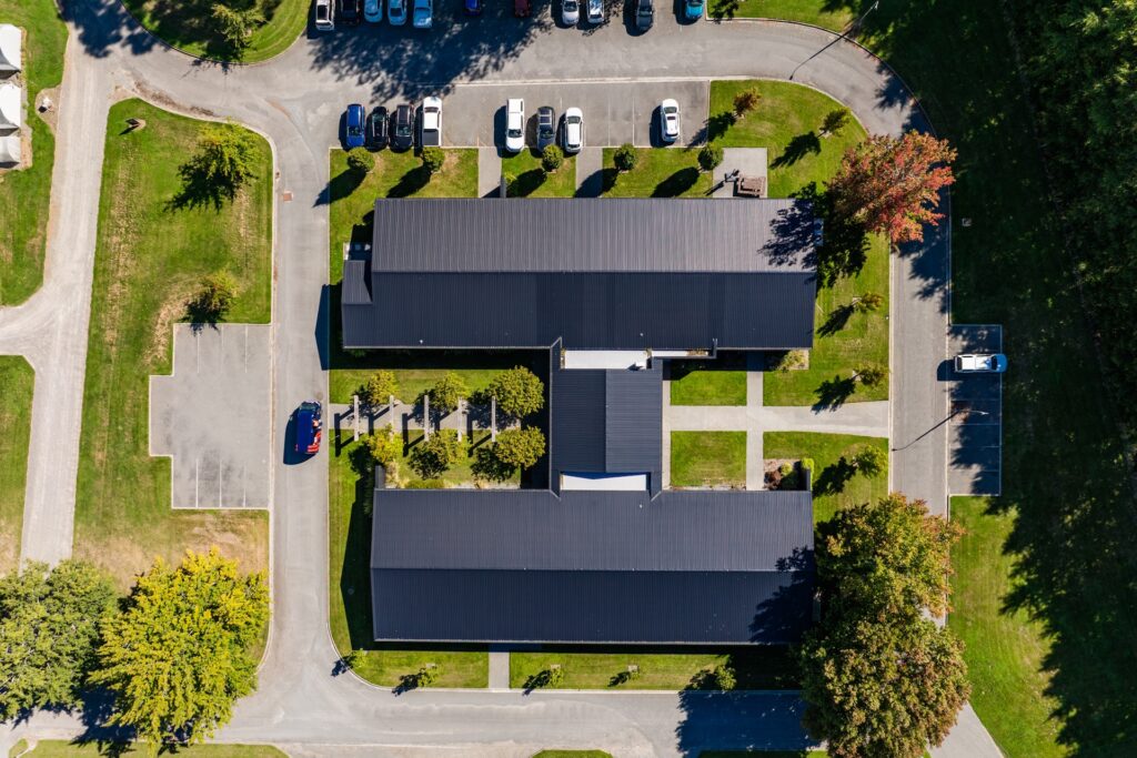 Maugers_Property_Innovation_Park_Drone_Shoot_13_3_26_Small_94 Overhead aerial view of commercial office complex at Innovation Park Christchurch featuring central courtyard, parking areas and landscaped grounds. Modern business property ideal for office leasing and corporate tenancy.